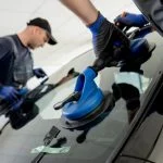 Technicien remplaçant un pare-brise sur place
